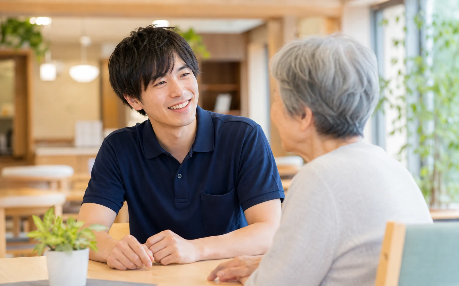 20代の介護職が高齢者施設で対話するイメージ