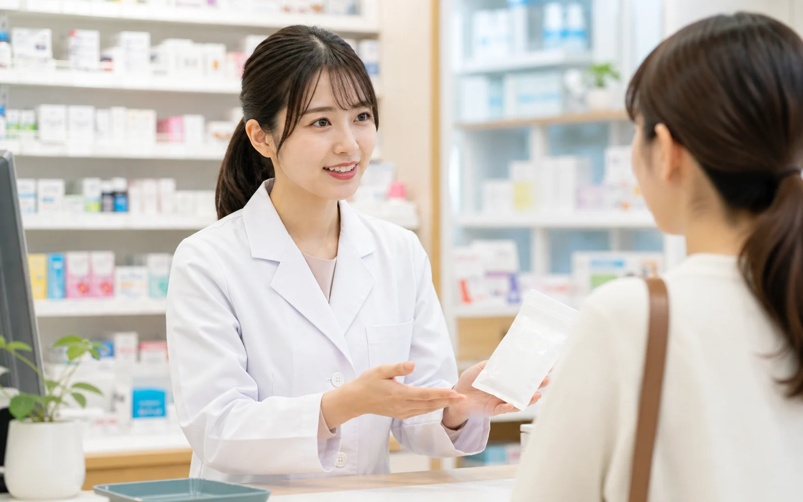 20代の薬剤師が薬局で服薬説明をするイメージ